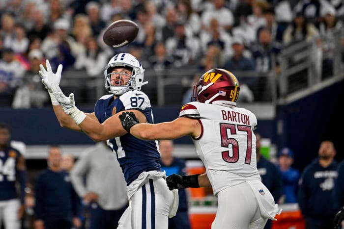 Dallas Cowboys tight end Jake Ferguson (87) catches a pass for a first down over Washington Commanders linebacker Cody Barton (57) during the first quarter at AT&T Stadium.